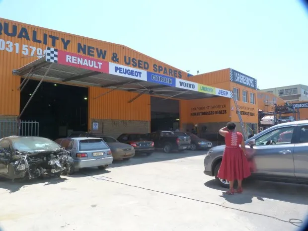 The SparesBoyz workshop entrance with vehicles outside, Renault first on the brand board